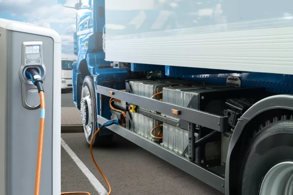 Concept rendering of white electric big rig truck plugged into charging station